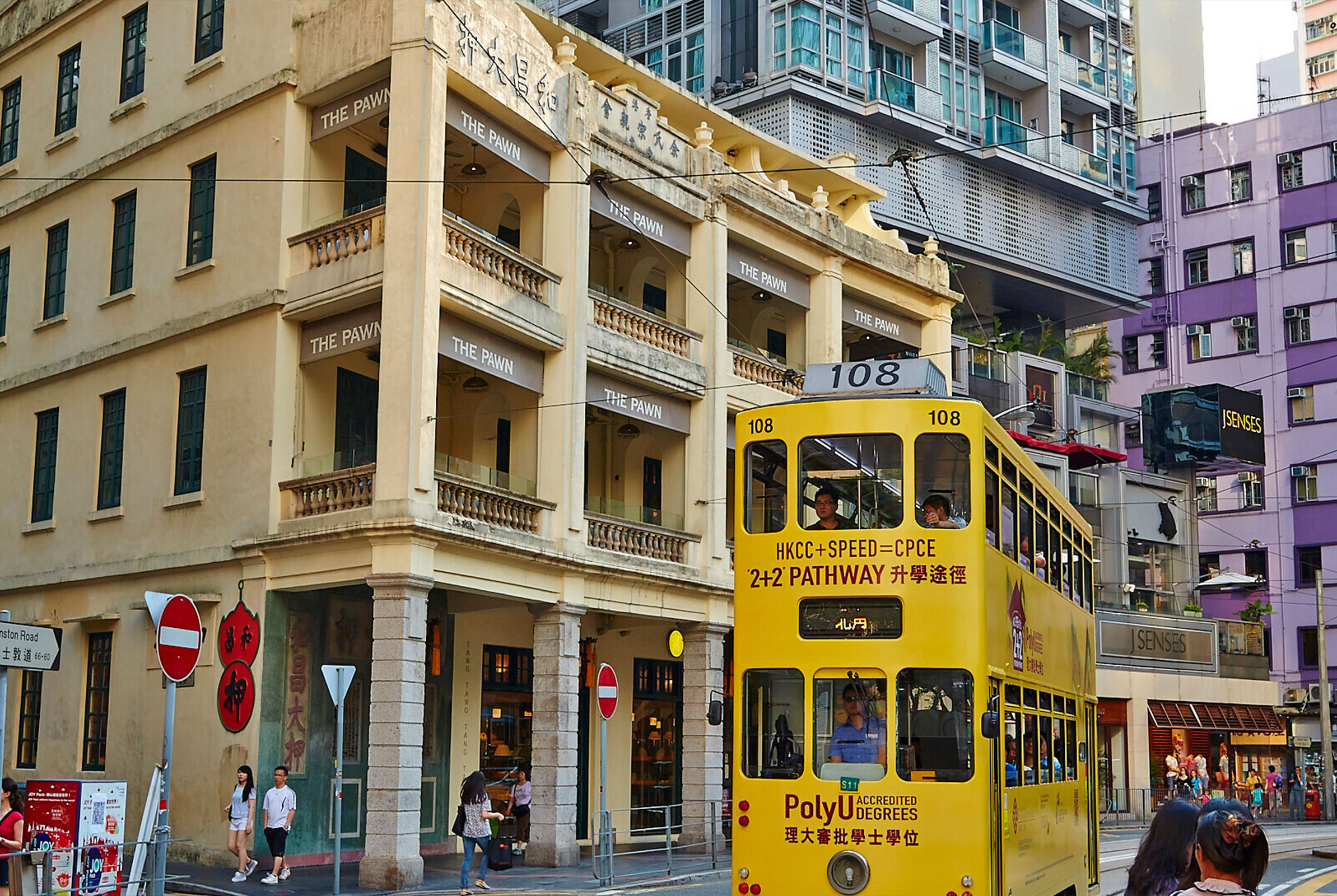 A yellow double-decker bus in the streets of Hong Kong