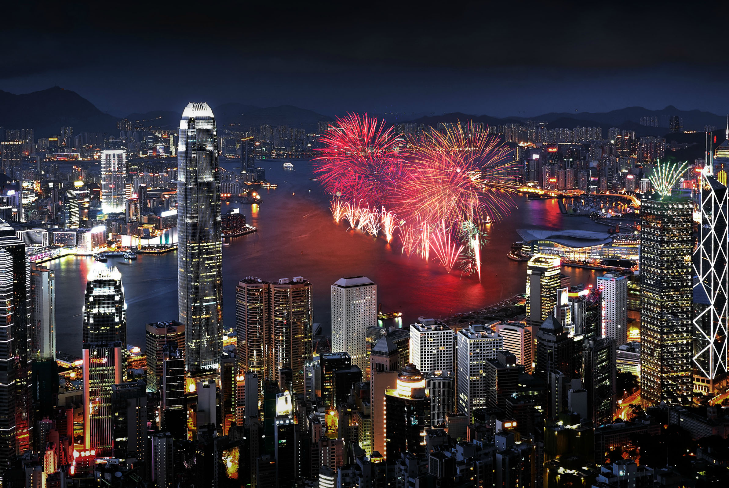Red fireworks line up Victoria Harbour for the New Year countdown.