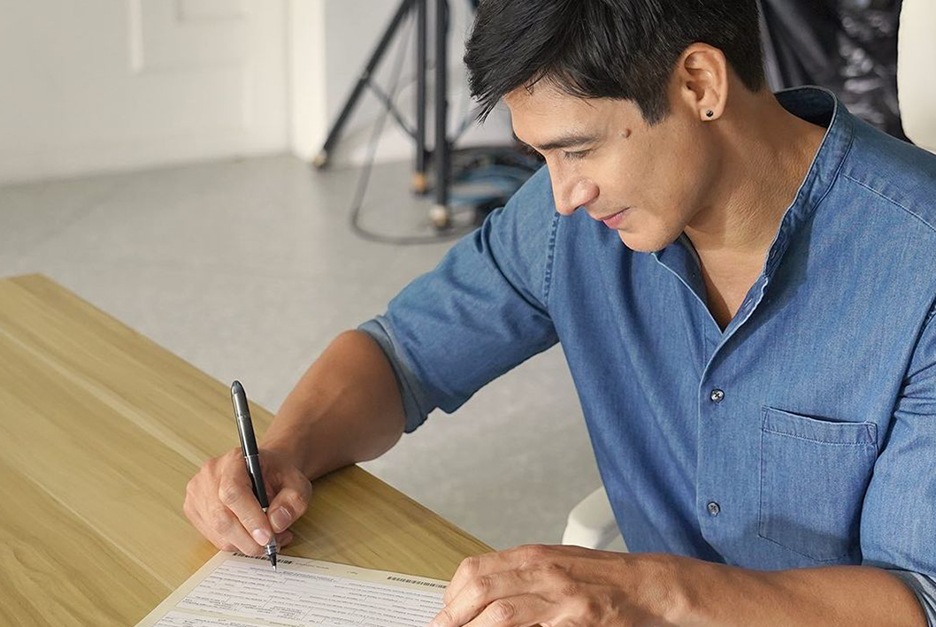 Piolo Pascual signing a Sun Life policy