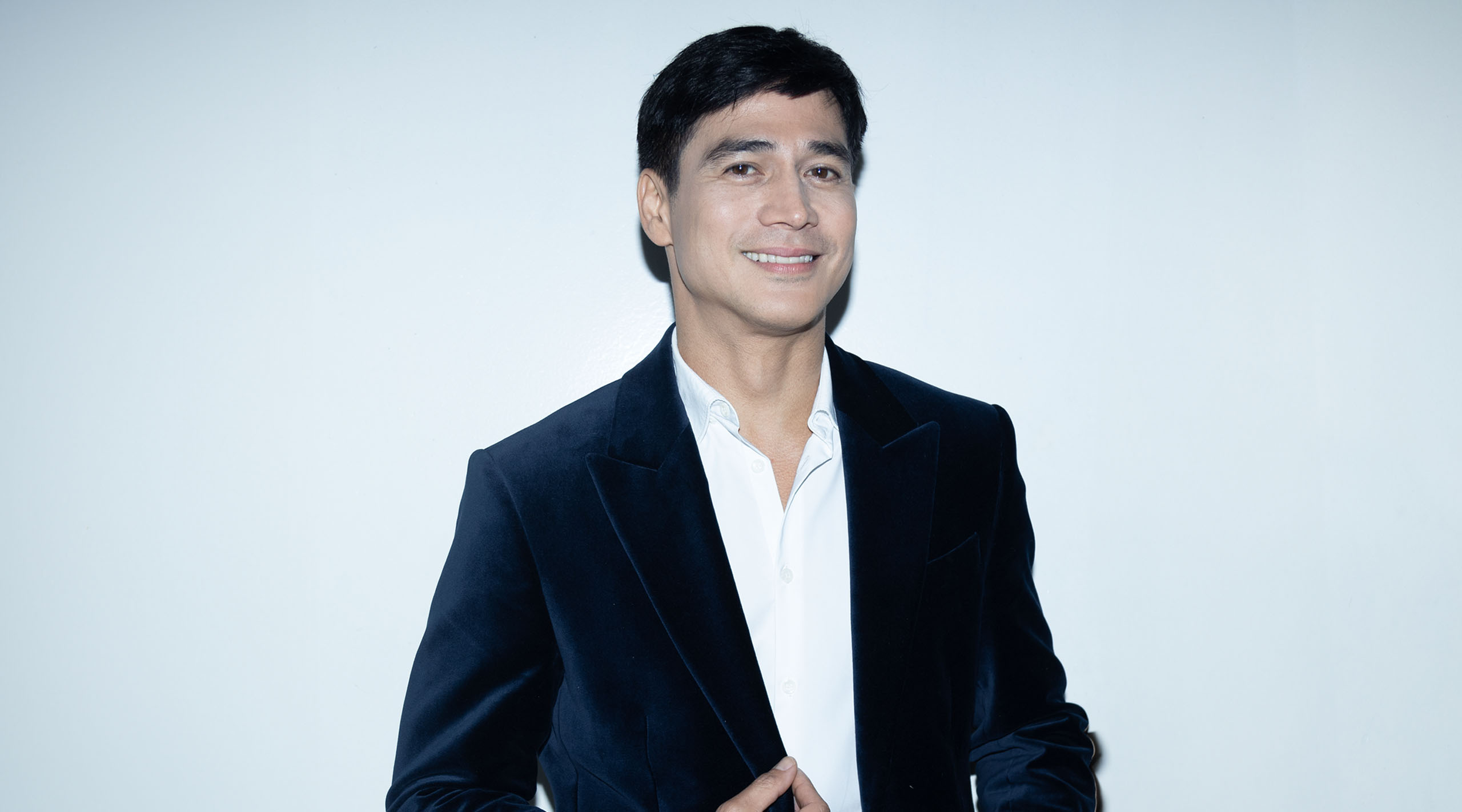 Piolo Pascual posing for a photo wearing a navy velvet suit.