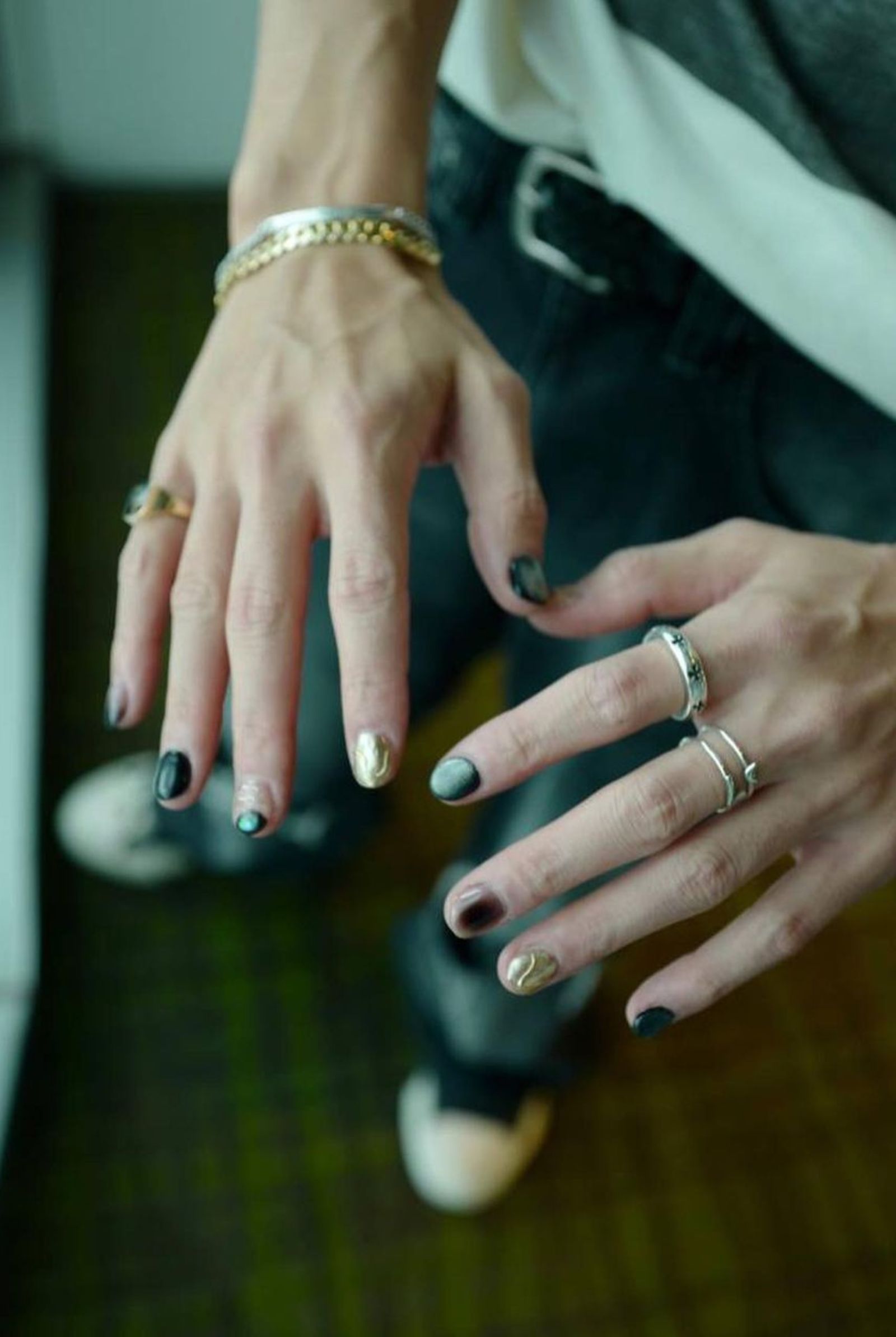 Using the colors black, gold, and silver, the nail artist provides the Korean idol with intricate nail designs.