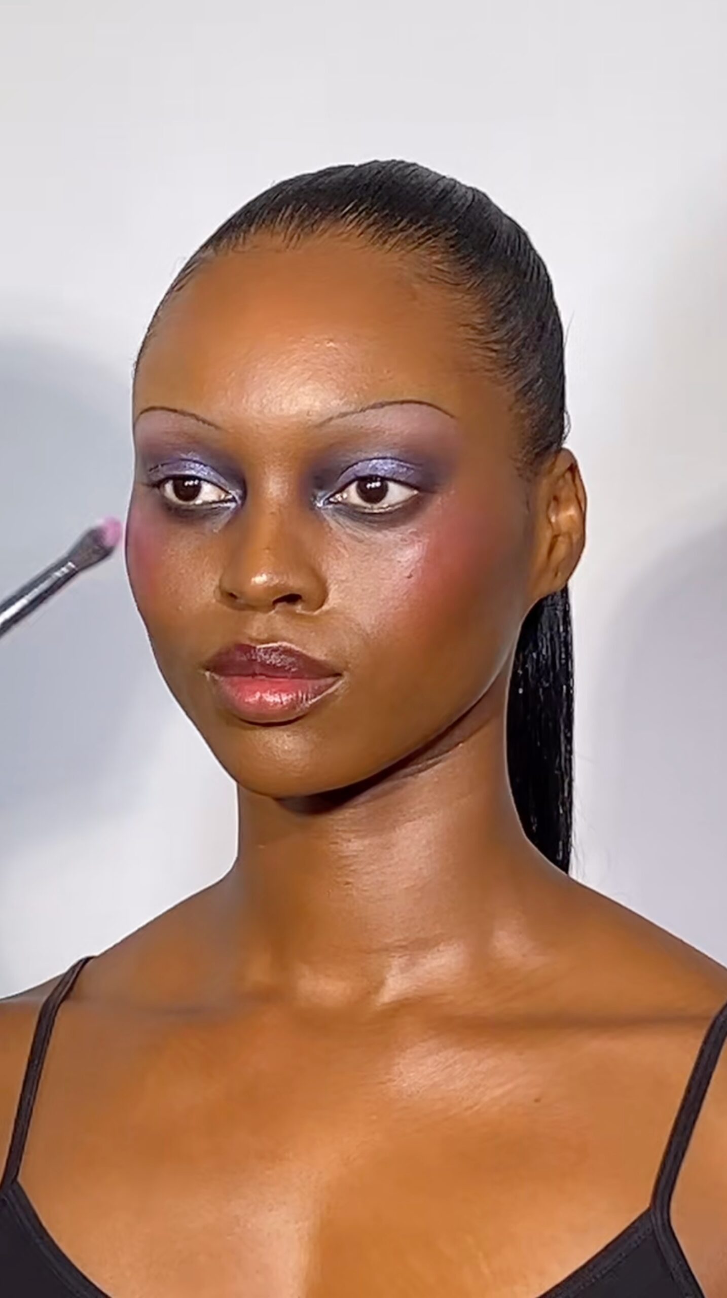 Team Pat McGrath applying a lavender MatteTrance™ Lipstick to LaPorcshia's cheekbones