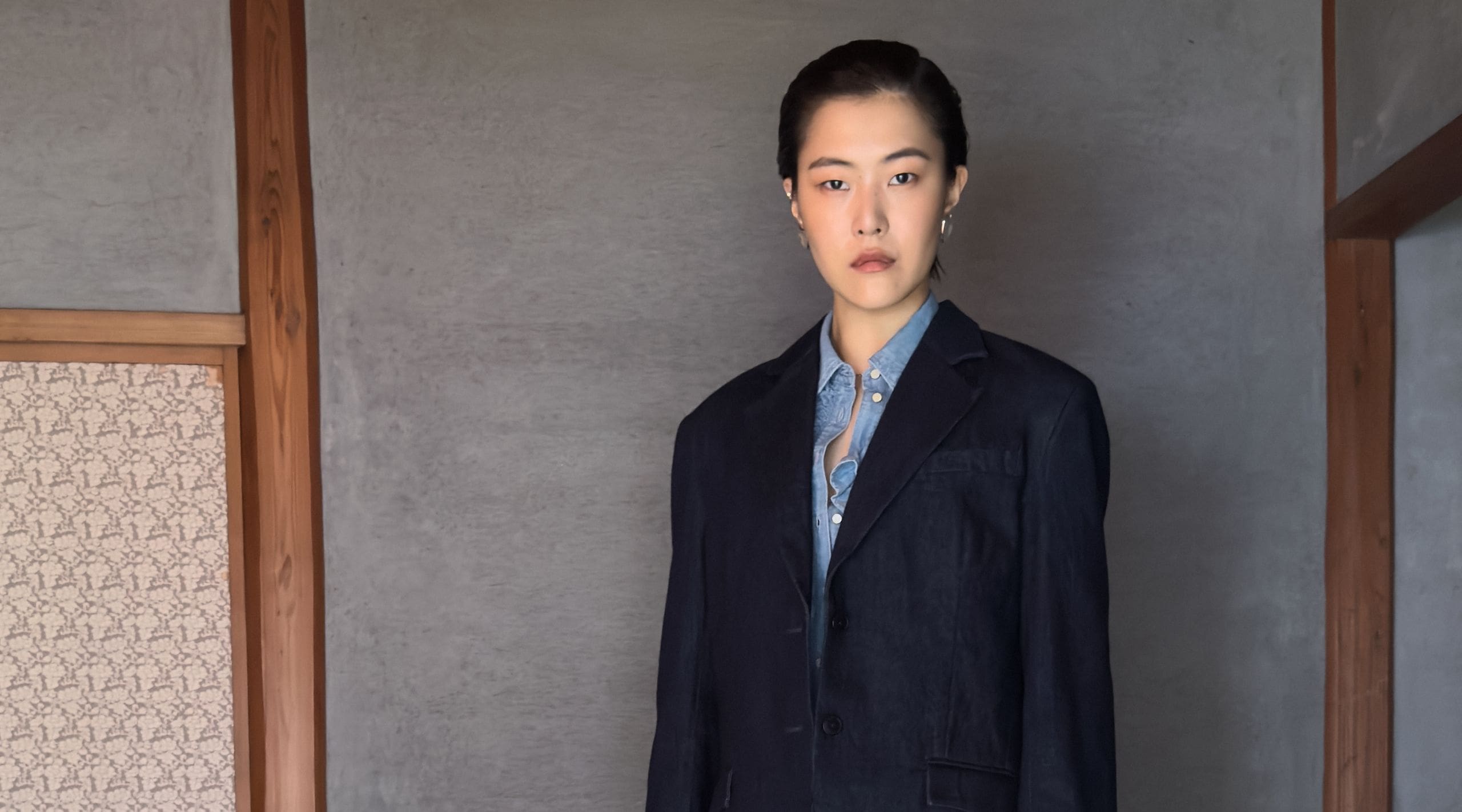 A model wearing a dark blue denim button down Blue Tab