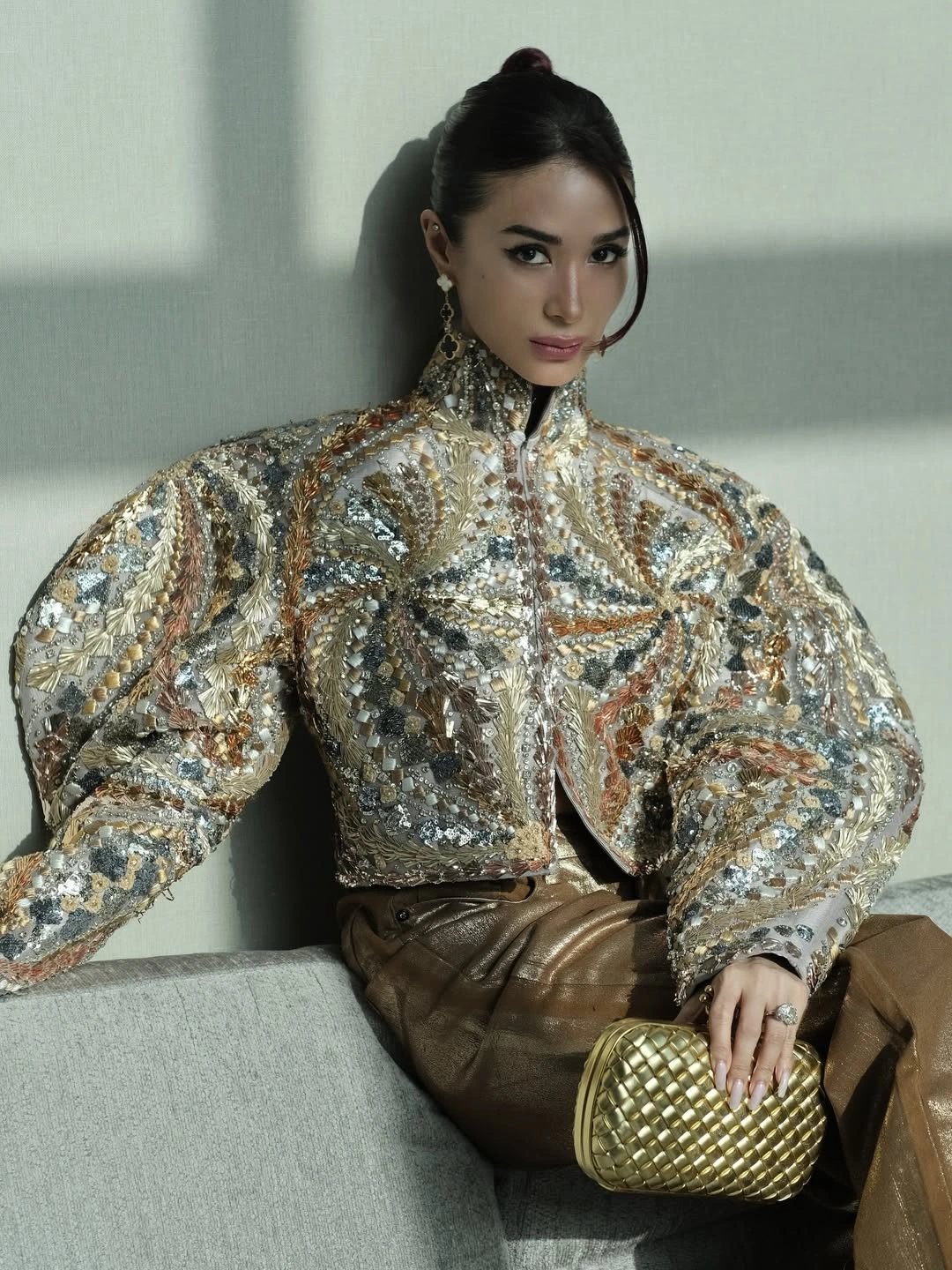 HEART EVANGELISTA WORE A EMBELLISHED JACKET AND GOLD-TONED PANTS WERE PAIRED WITH A BOTTEGA VENETA GOLDEN CLUTCH