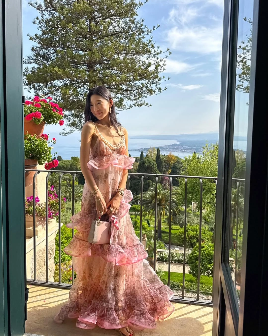 Becca Bloom in a Zimmerman dress, carrying a Lady Dior bag
