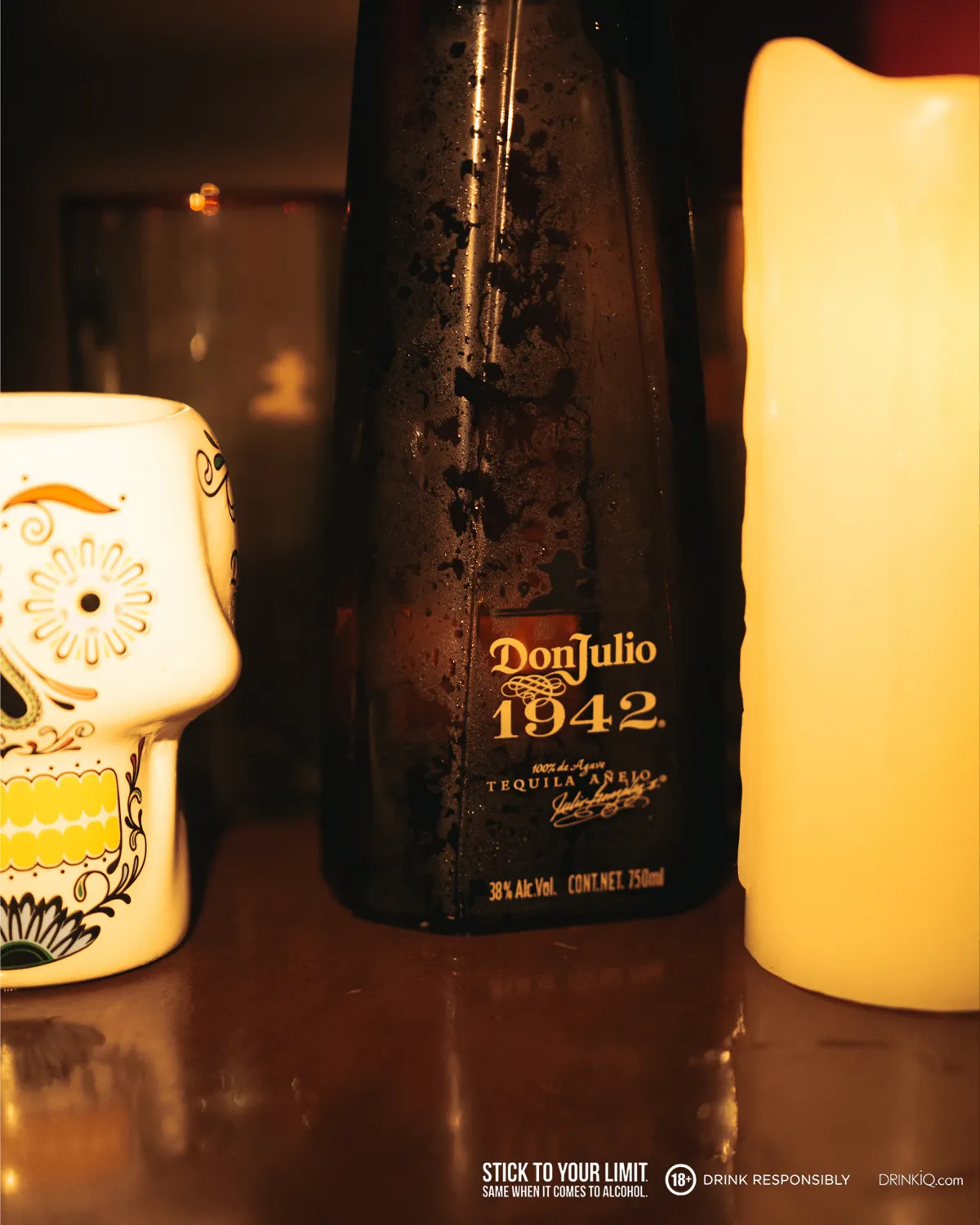 Don Julio 1942 flanked by a mug and candle 