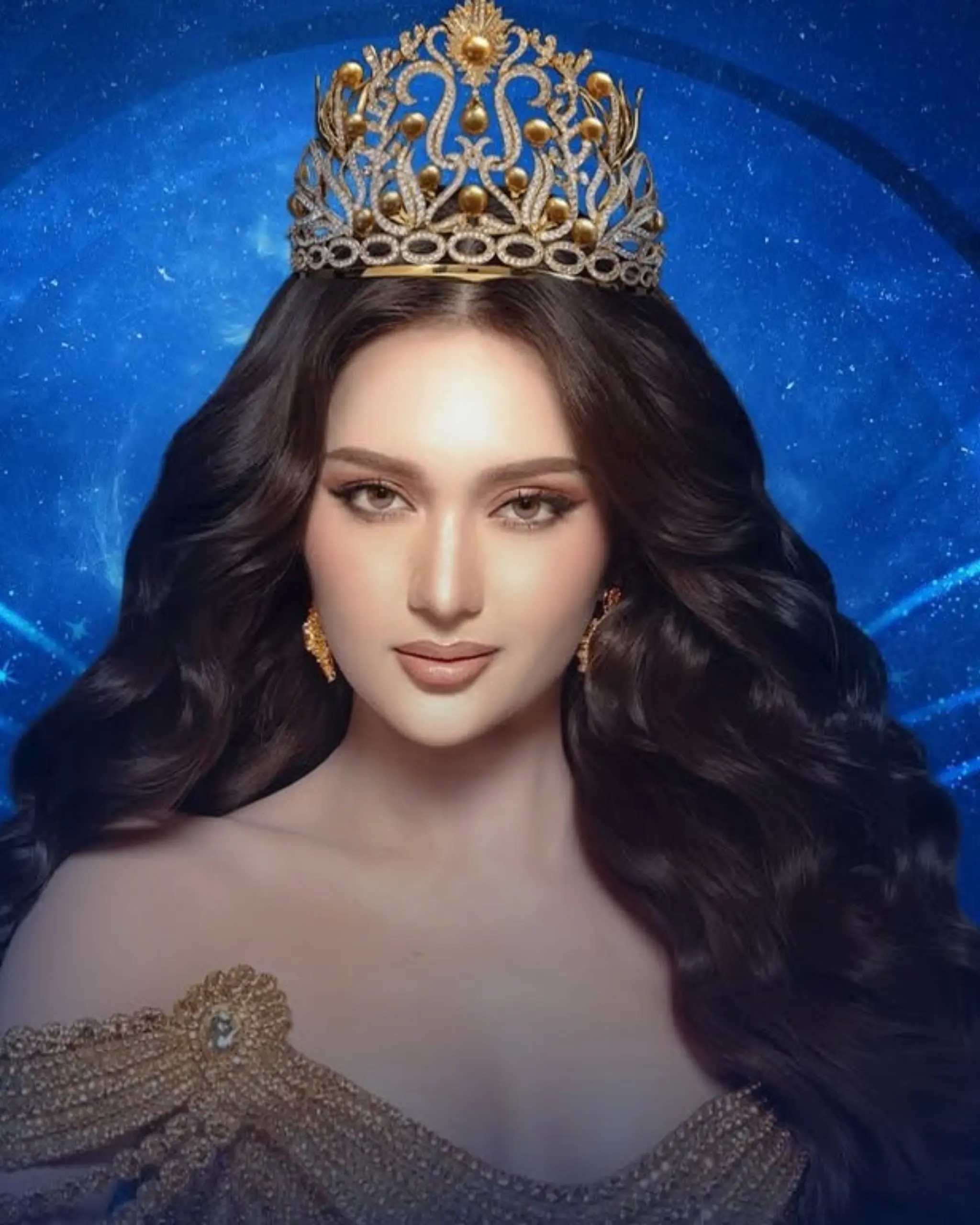 Woman wearing an ornate gold crown and off-shoulder beaded gown against a blue backdrop.