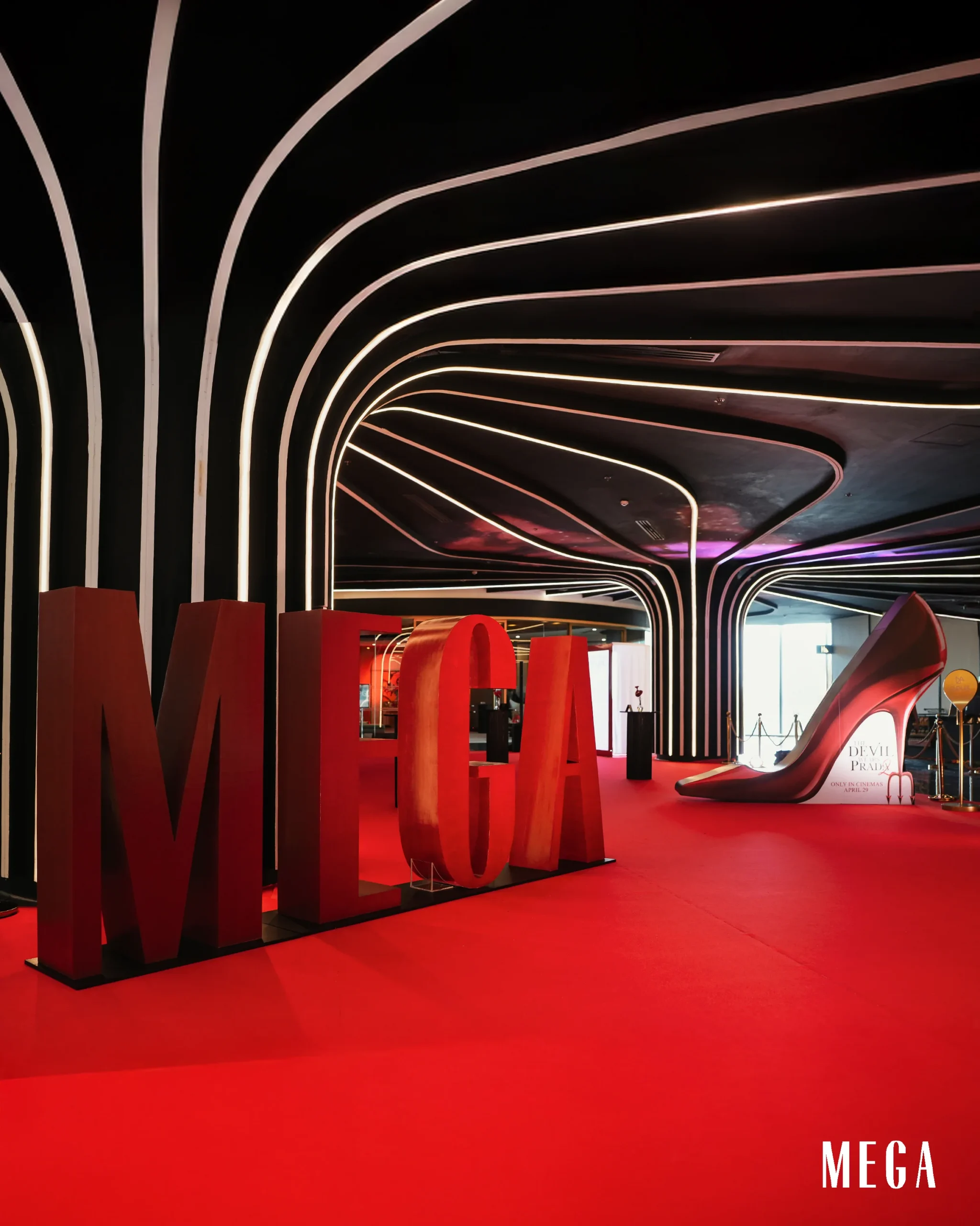 Red-lit gallery with curved white neon arches and oversized red MEGA letters on a red floor.