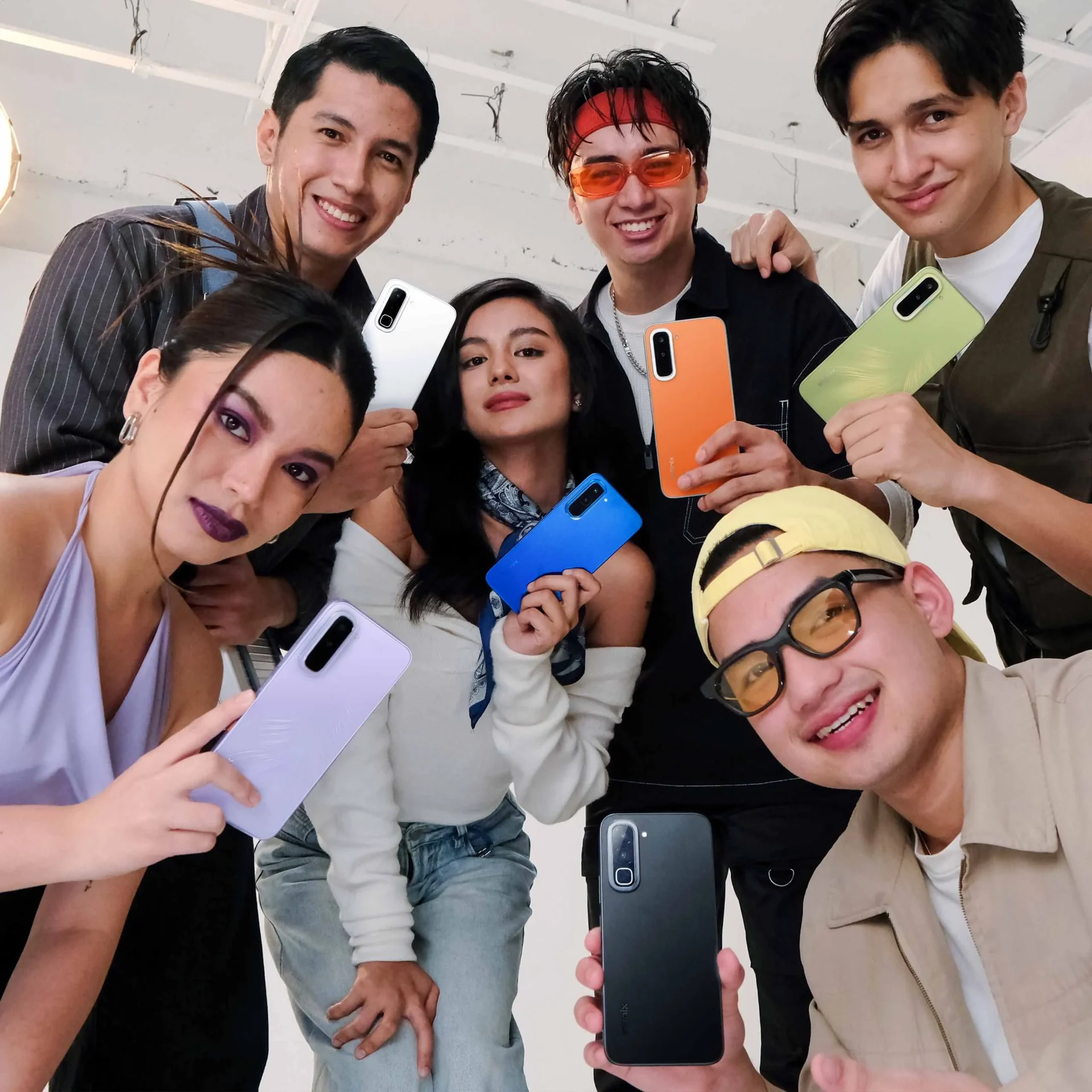 Young adults each holding a new variant for the Infinix HOT 70