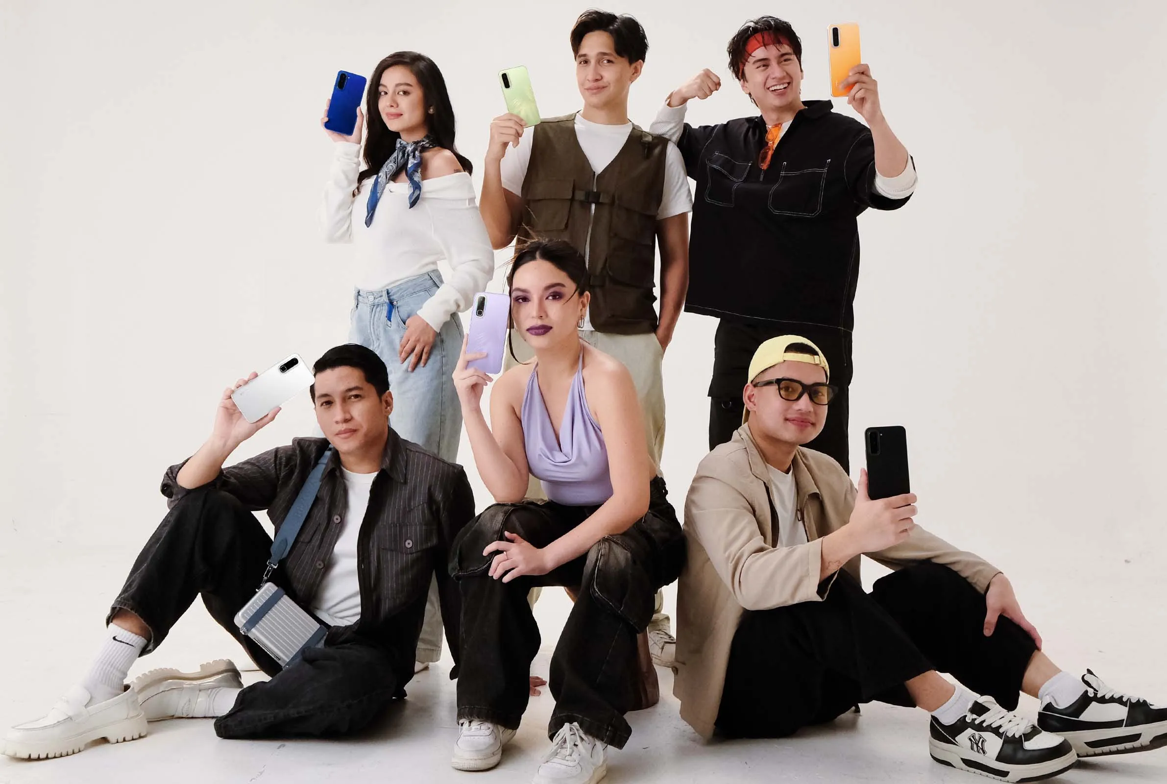 Young adults each holding the new Infinix HOT 70 variants