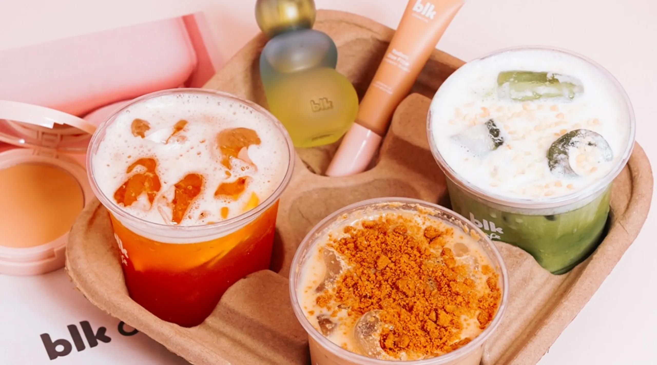 Assorted colorful bubble tea drinks with toppings on a brown serving tray in clear cups.