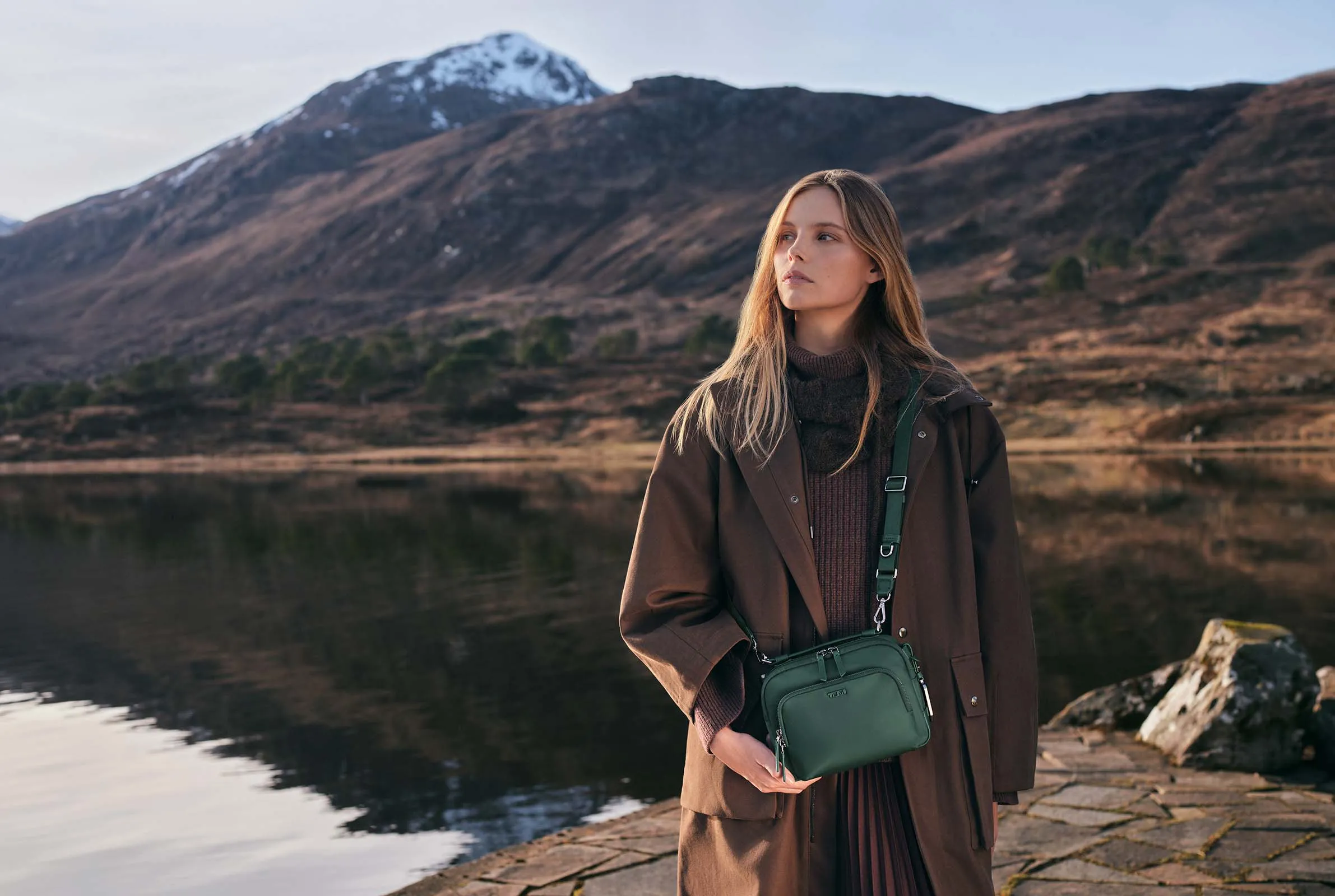 Woman in the alps with her Deep Pine Teghan Crossbody