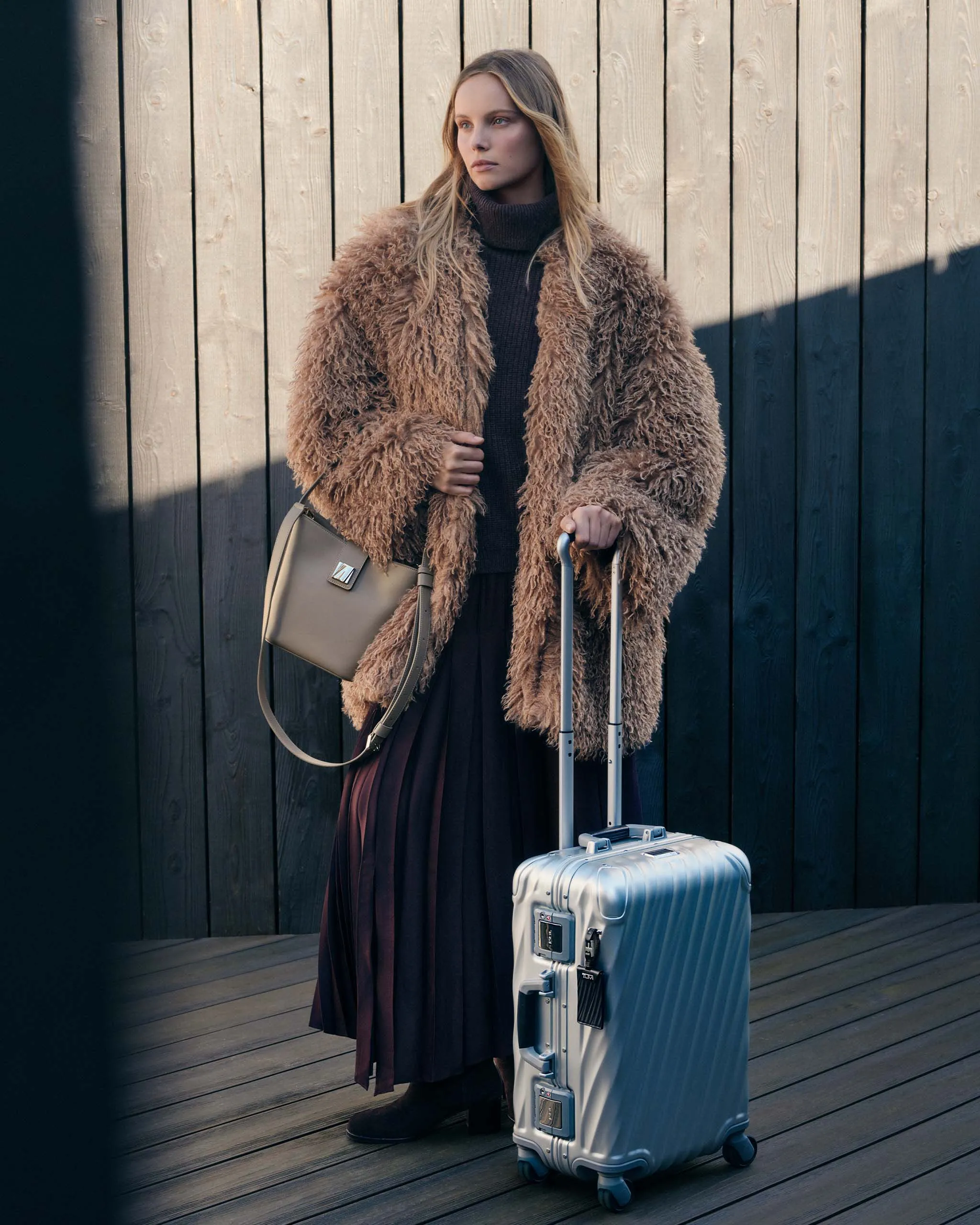 A traveling woman with her TUMI bag and carry-on
